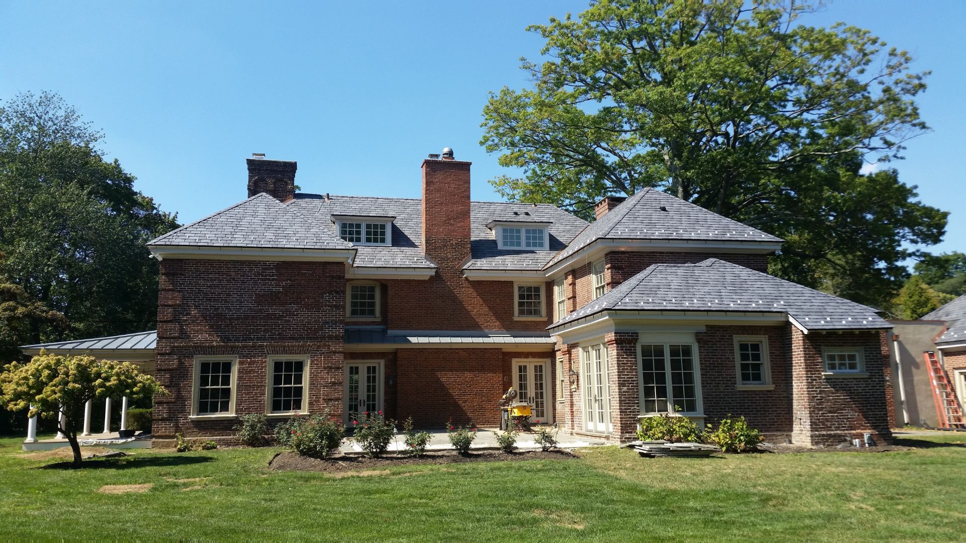 Stunning slate roofing with bold, sharp edges on this red brick on this colonel estate