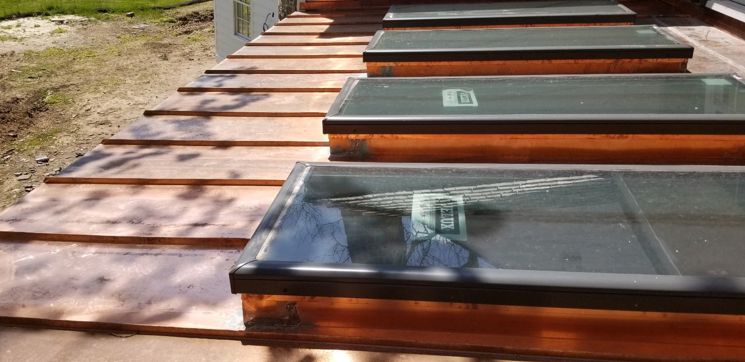 In-progress gently sloped roof with windows skylights