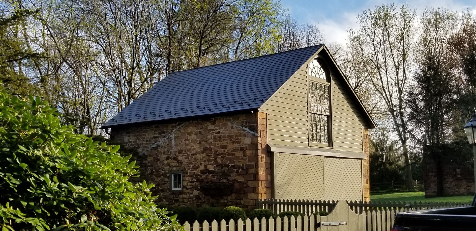 Traditional slate roofing with snow guards and wood siding on this colonel barn